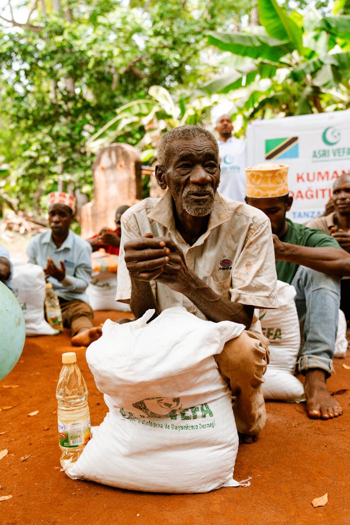 about-us An elderly man with a food package during a distribution event in a rural setting.