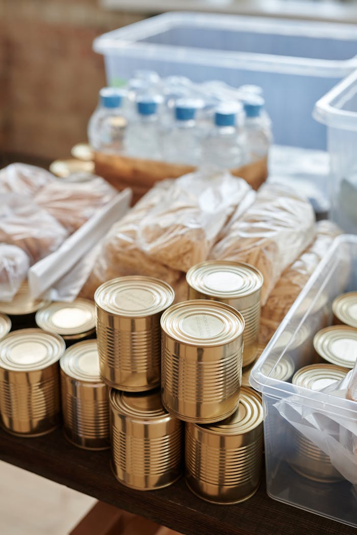 our-story A variety of canned goods and packaged items arranged for a donation drive or food bank collection.